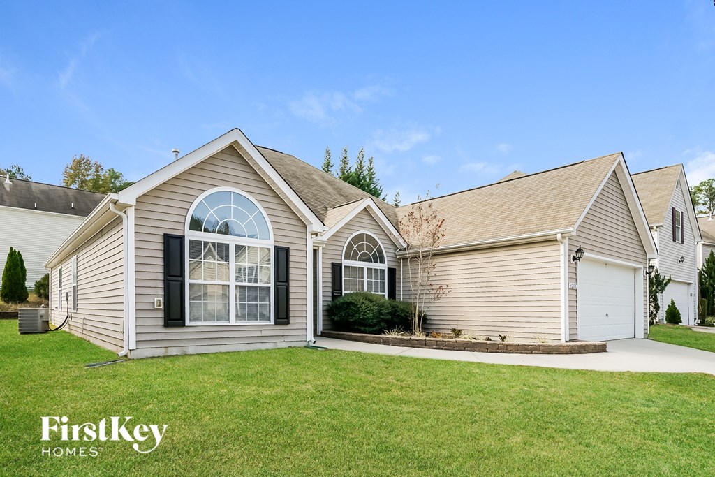 the front of a house with a lawn and a driveway
