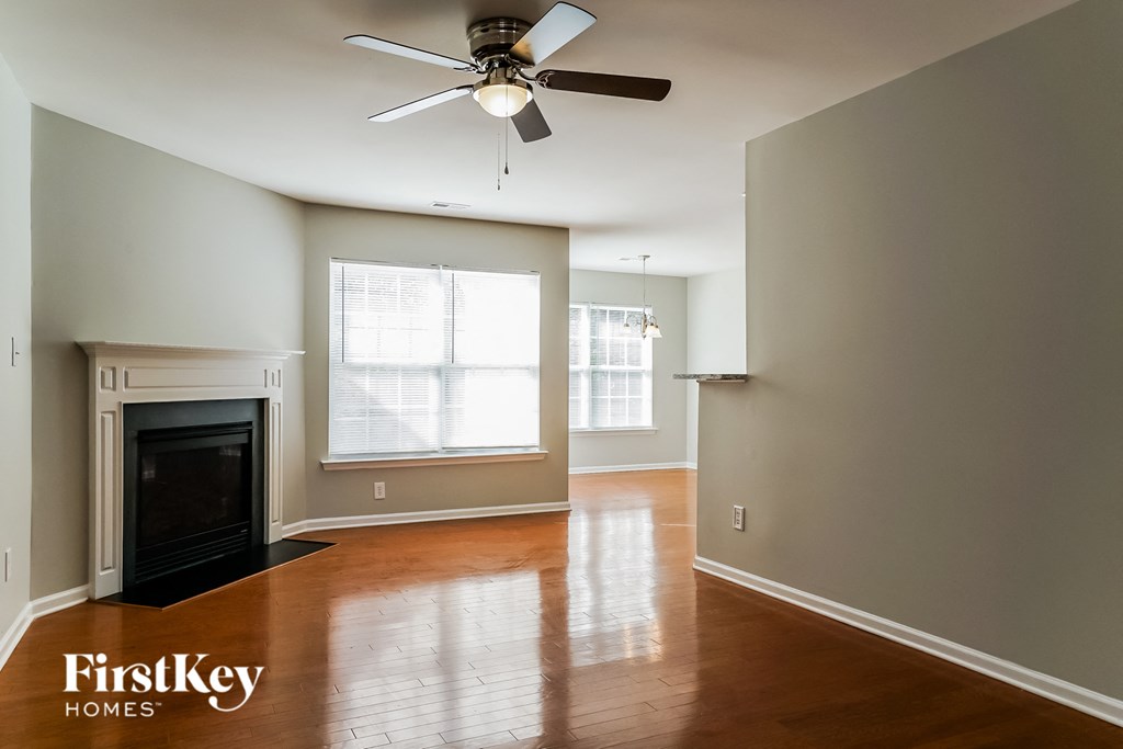 a living room with a fireplace and a ceiling fan