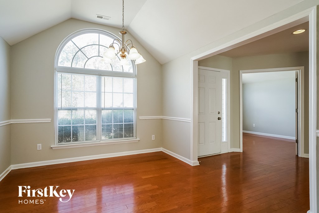 an empty living room with a large window and a door