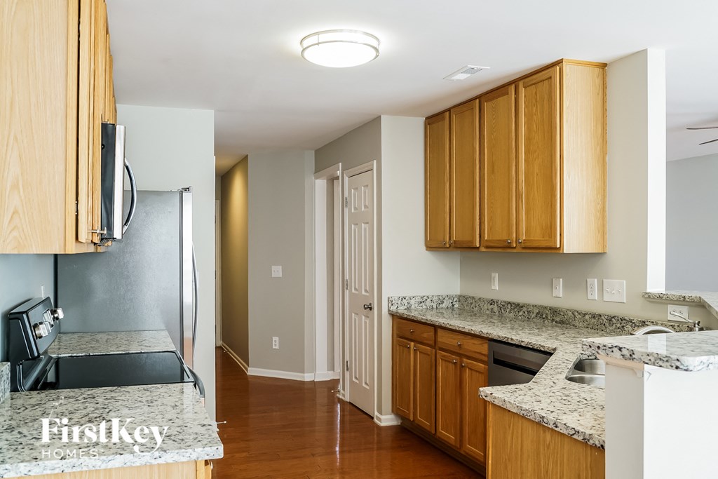 a kitchen with wood cabinets and granite counter tops and a refrigerator