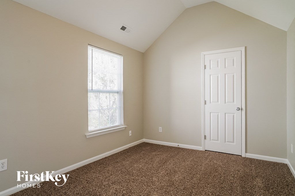 a bedroom with a white door and a window