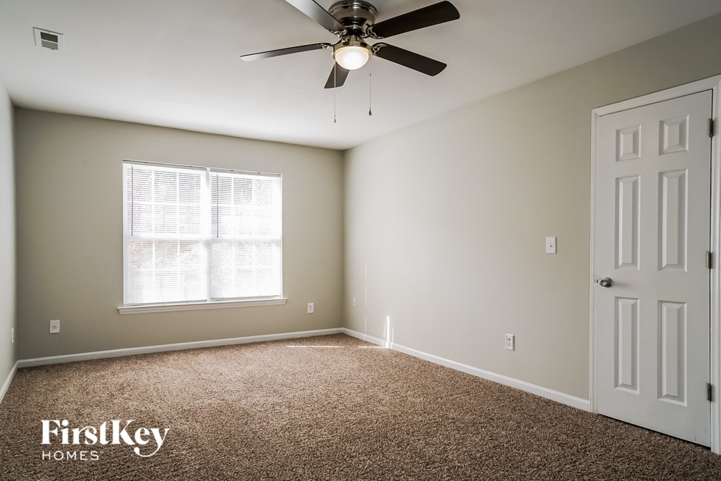 a bedroom with a ceiling fan and a white door