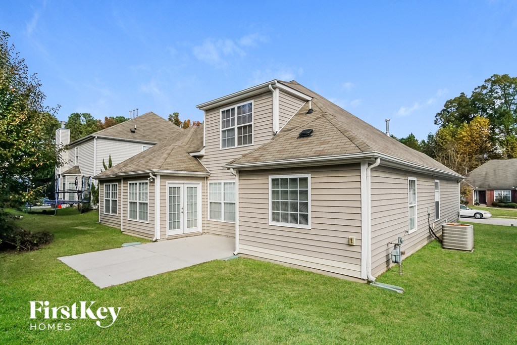the backyard of a house with a yard and a sidewalk