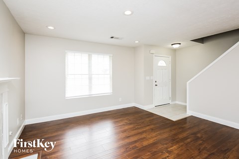 a living room with wood floors and a white door