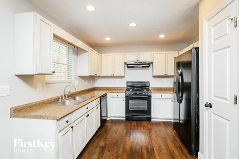 a kitchen with white cabinets and a black stove and refrigerator