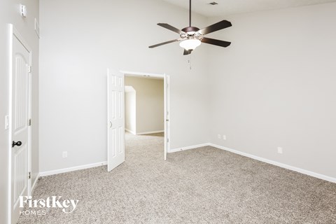 a empty room with a ceiling fan and a door to a closet