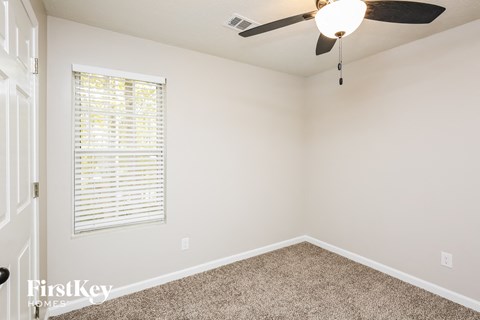 a bedroom with a ceiling fan and a window