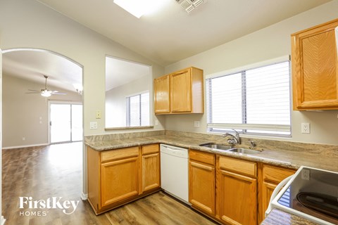 A kitchen with wooden cabinets and a white dishwasher.