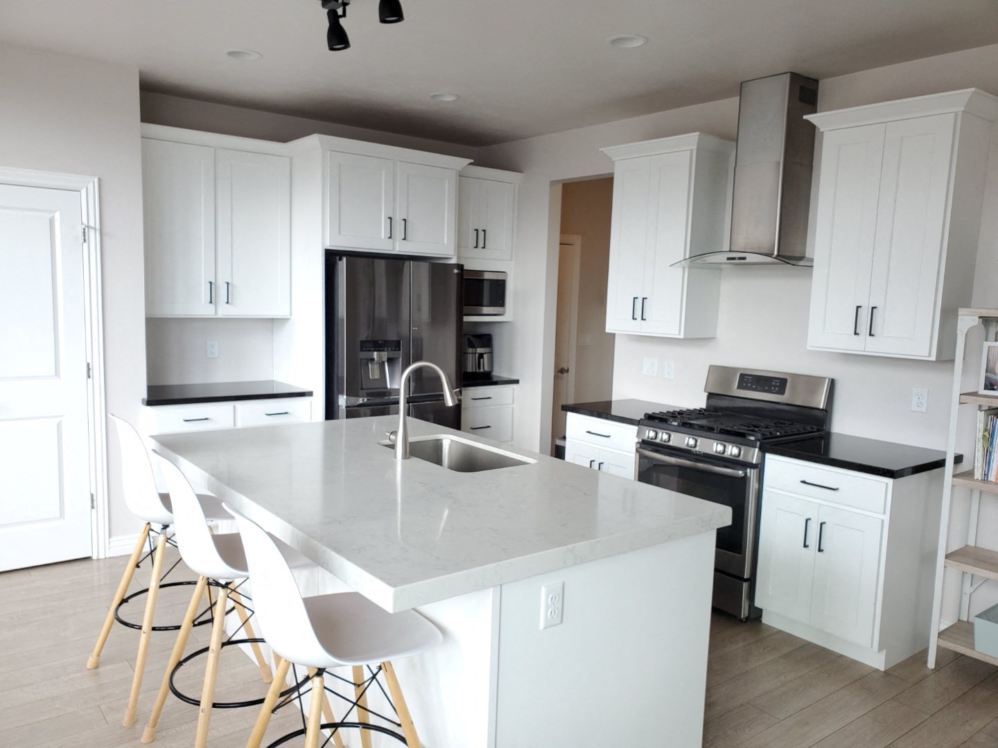a white kitchen with stainless steel appliances and white cabinets