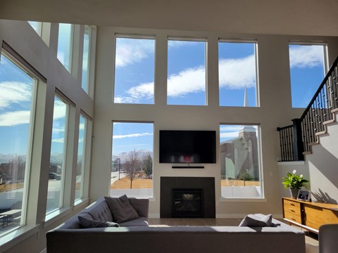 a living room with large windows and a couch and a television