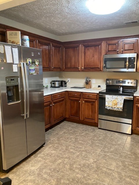 A kitchen with wooden cabinets and a stainless steel refrigerator.