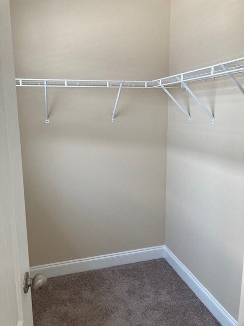 a walk in closet with white racks on the wall