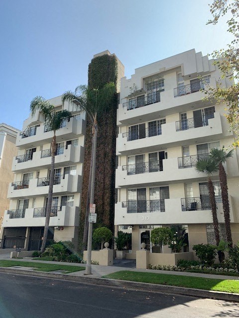 a tall building with palm trees in front of it
