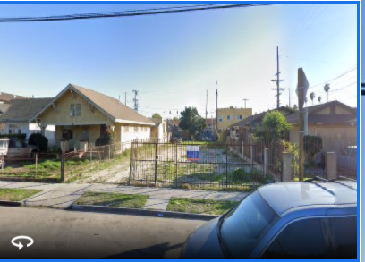 a view of a yard with a fence and some houses