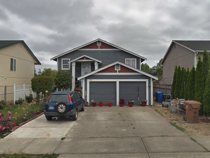 a blue car parked in front of a house