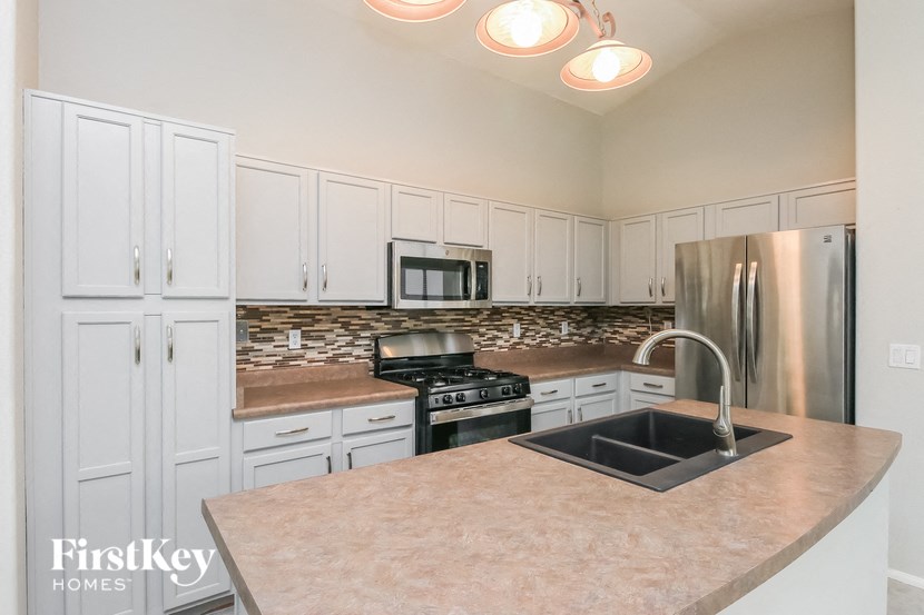 A kitchen with a stove top oven and a refrigerator.