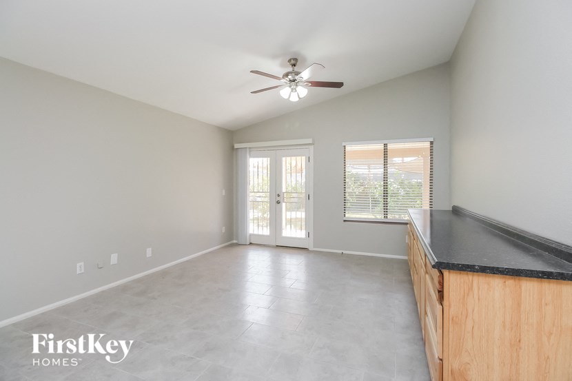 A spacious room with a ceiling fan and sliding glass doors.
