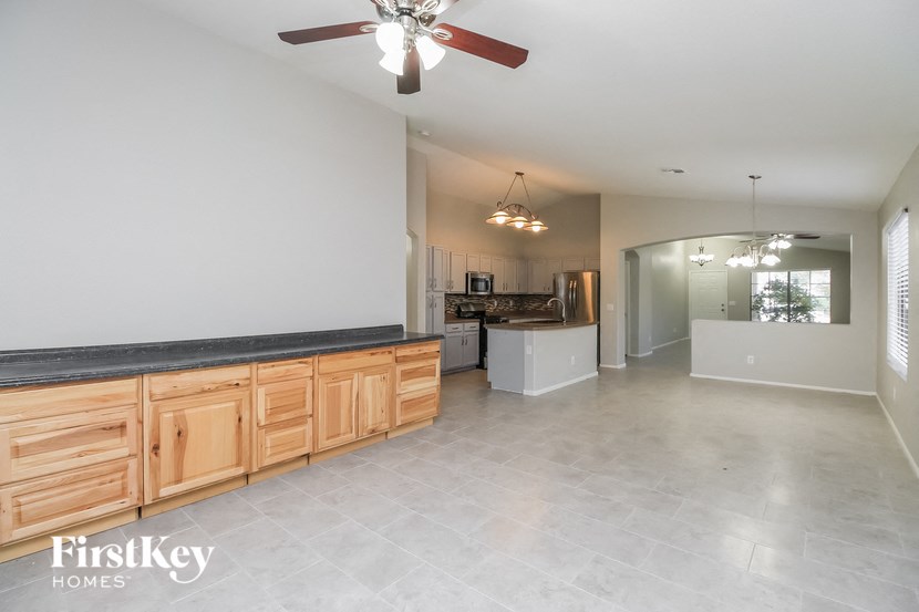 A spacious kitchen with wooden cabinets and a ceiling fan.