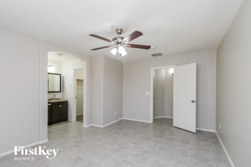 A spacious room with a ceiling fan and a tiled floor.