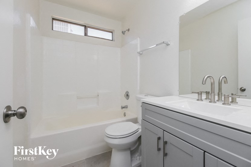 A white bathroom with a toilet, sink, and tub.