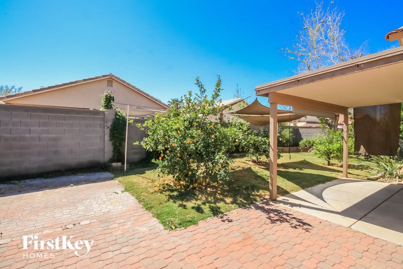 A house with a brick pathway leading to a covered patio area.