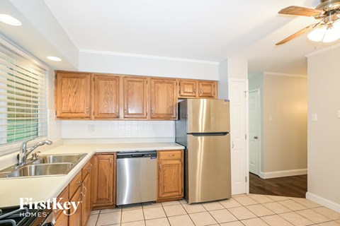 A kitchen with wooden cabinets and a stainless steel refrigerator.