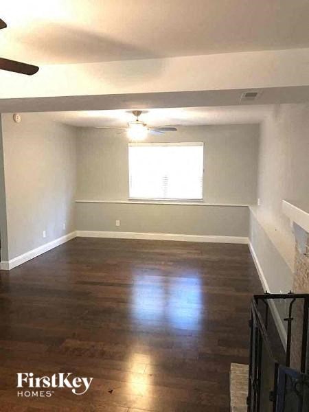 A room with wooden floors and a ceiling fan.