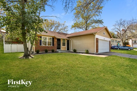 a house with a lawn and a tree in front of it