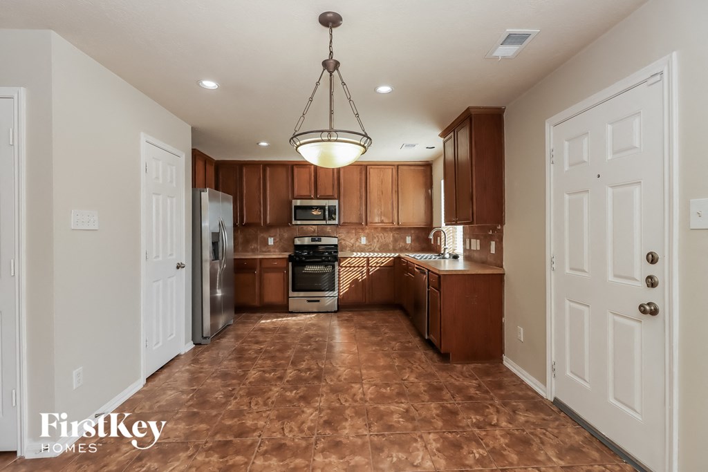 a kitchen with wooden cabinets and stainless steel appliances