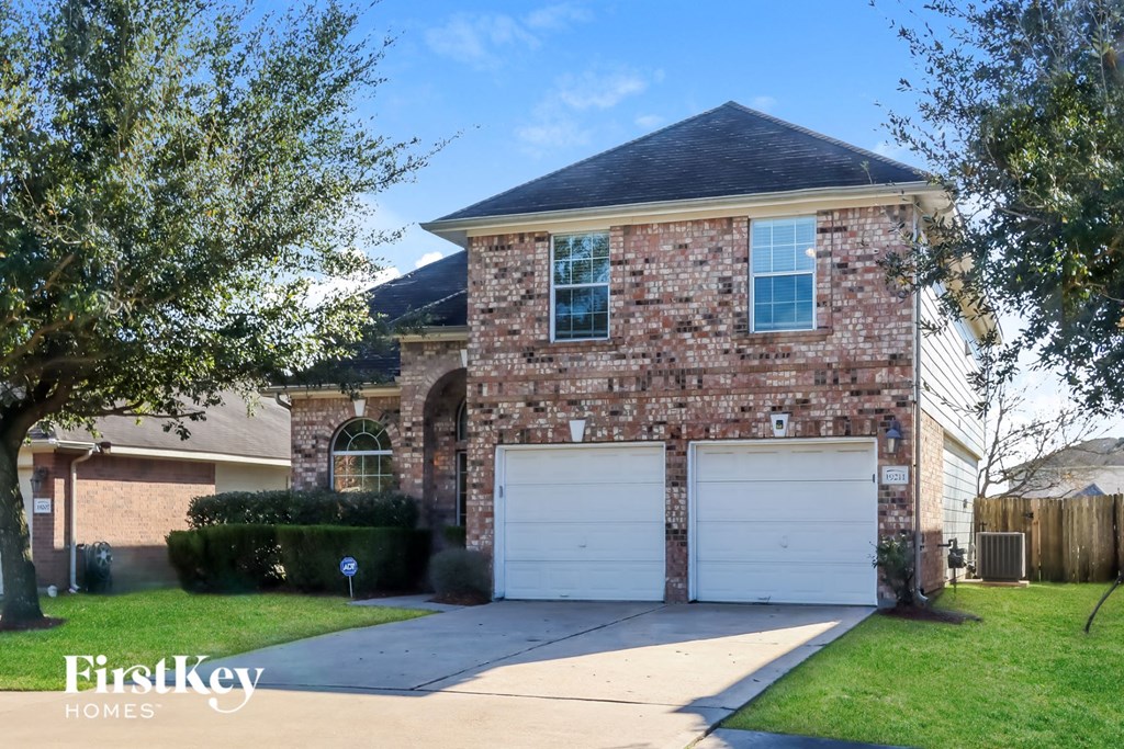 a brick house with two white garage doors