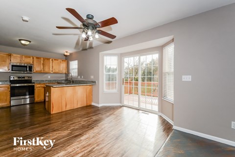 A kitchen with wooden cabinets and a fan on the ceiling.