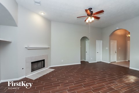 a living room with a fireplace and a ceiling fan