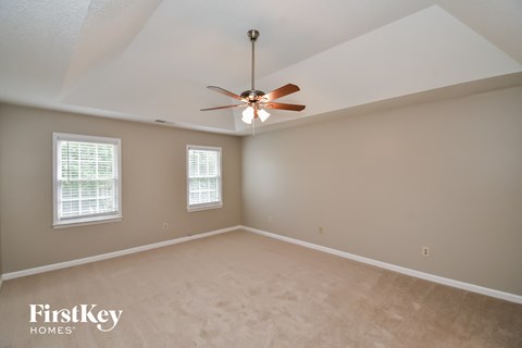 the master bedroom is spacious and has a ceiling fan