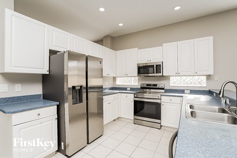 a white kitchen with stainless steel appliances and white cabinets