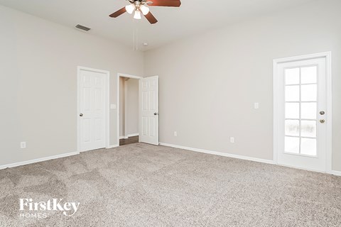 a bedroom with a carpeted floor and a ceiling fan
