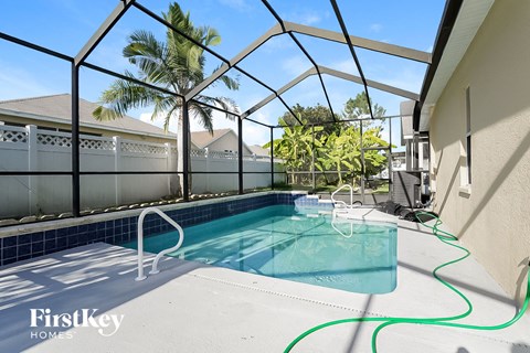 pool and spa area in the backyard of a house with palm trees