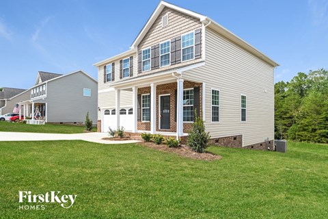 a home with a lawn and a sidewalk in front of it