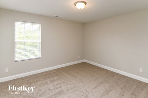 a bedroom with white carpet and a window