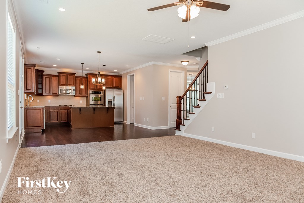 A spacious living room with a staircase leading to the upper floor.