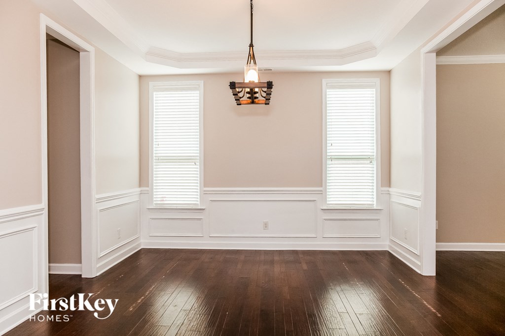 A well-lit room with wooden floors and a chandelier.
