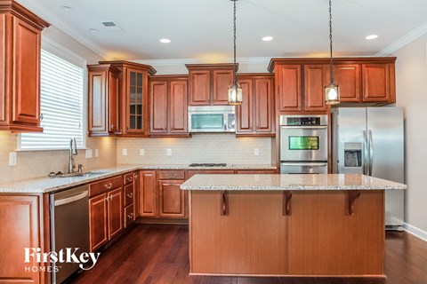 A kitchen with wooden cabinets and a marble countertop.