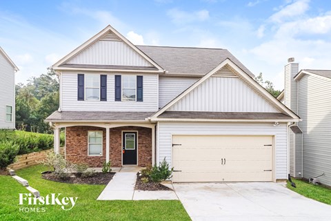 a white and brick house with a white garage door