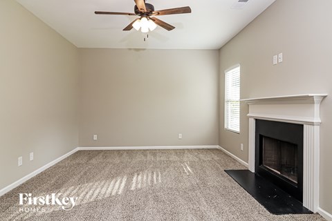 a living room with a fireplace and a ceiling fan