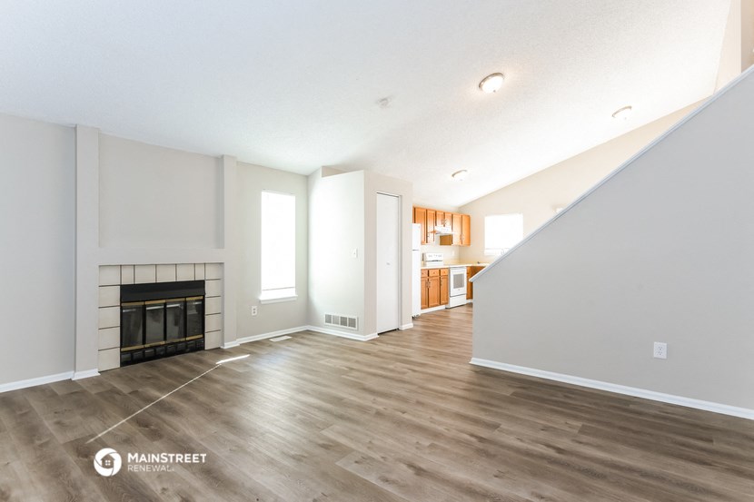 a living room with a fireplace and wooden floors