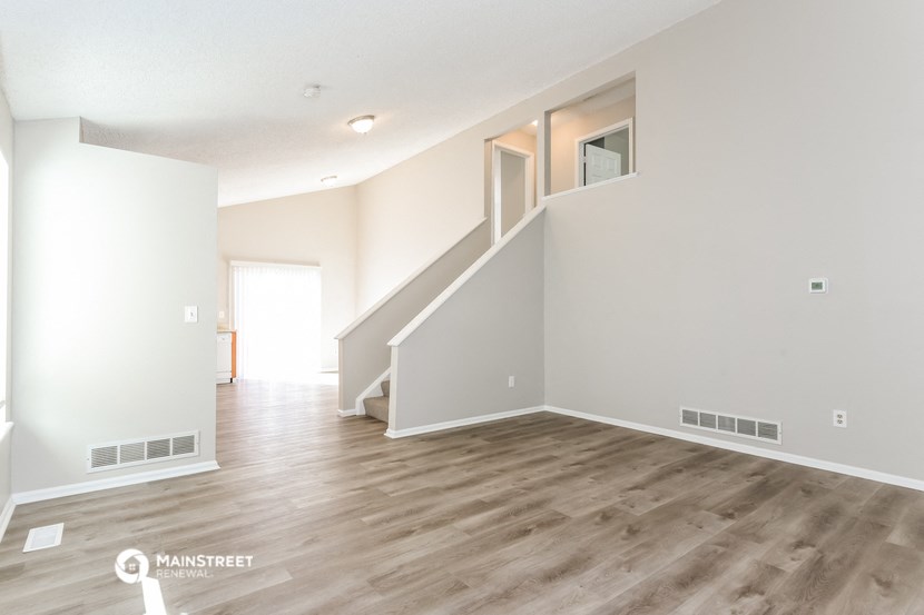 an empty living room with white walls and wood floors