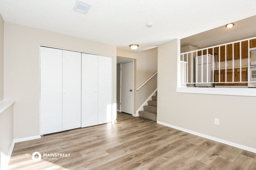 a renovated living room with white walls and wood floors