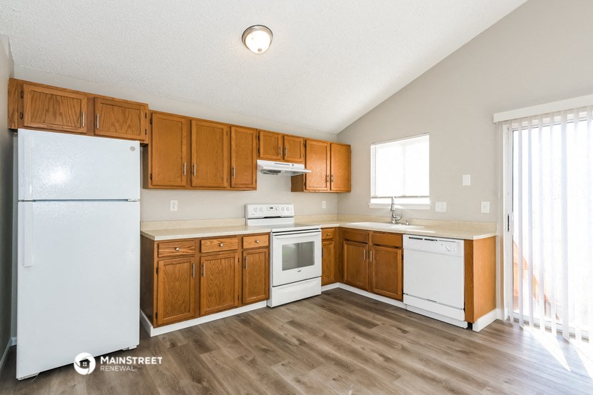 a kitchen with white appliances and wooden cabinets