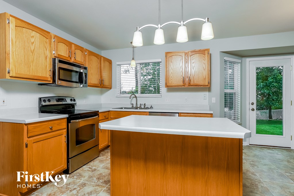 a kitchen with wooden cabinets and a white counter top