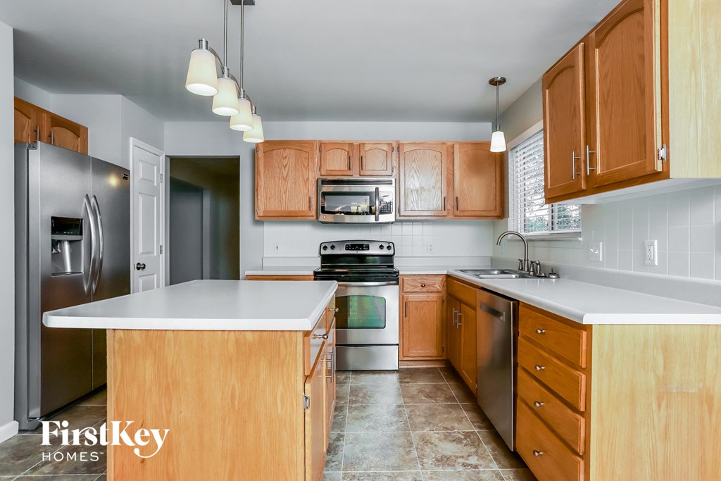 a kitchen with wooden cabinets and stainless steel appliances