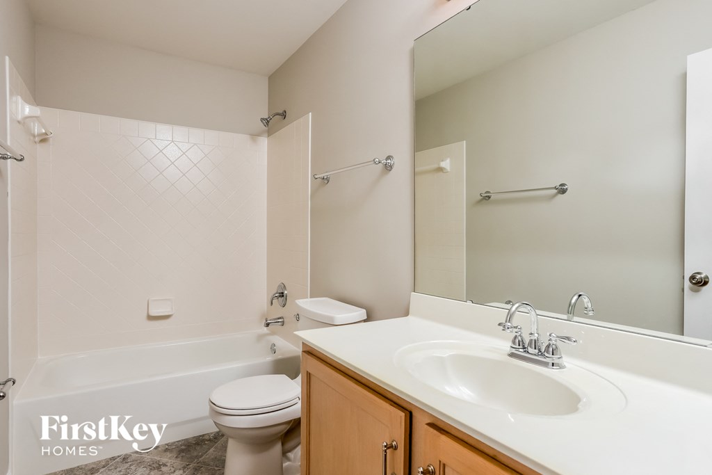 a bathroom with a sink toilet and tub and a mirror
